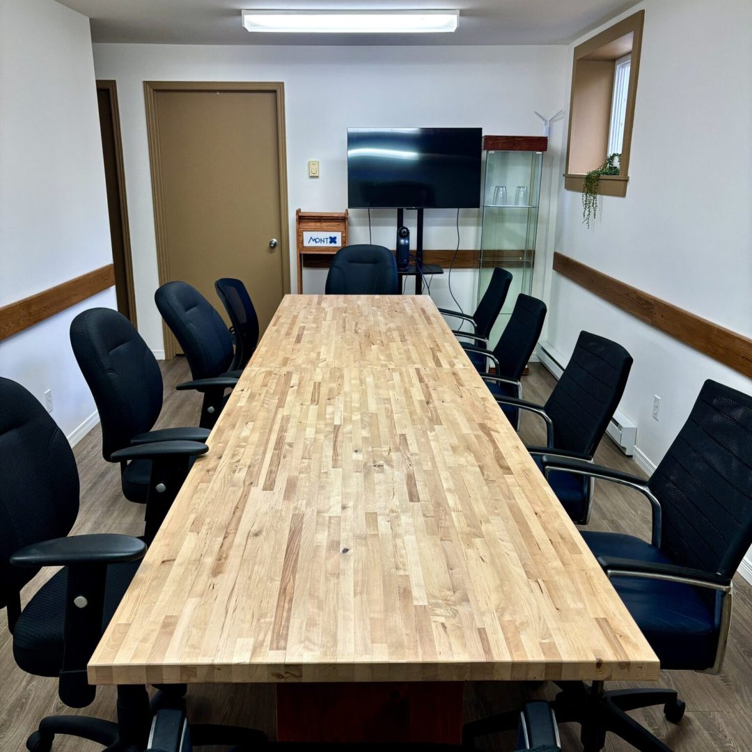Salle de réunion de Mont X avec grande table et écran